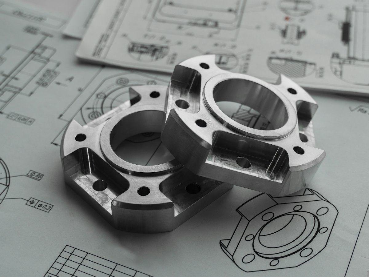 Teknik çizimler üzerinde işlenmiş metal parçalar